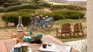 een picknicktafel met een fles wijn en glazen bij Hôtel Île de Lumière in La Cotinière