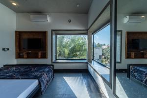 Un dormitorio con dos camas y una gran ventana. en Mermaid Farm House, en Pondicherry
