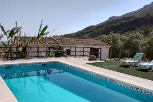 una piscina frente a una casa en El Ventorrillo la alegría en Málaga