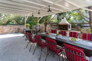een patio met een tafel en stoelen en een fornuis bij Villa Astravi in Ialyssos