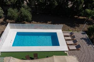 een uitzicht over een zwembad met stoelen bij Villa Astravi in Ialyssos
