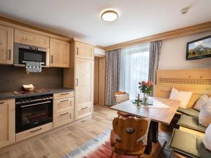 a kitchen with wooden cabinets and a table and a couch at Schnapperhof in Going am Wilden Kaiser