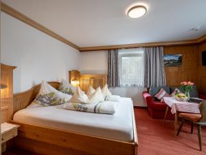 a bedroom with a large bed and a red couch at Schnapperhof in Going am Wilden Kaiser