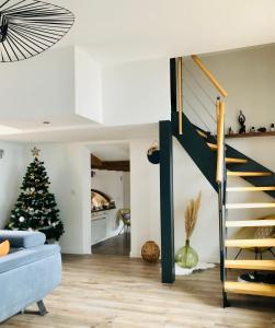 a living room with a christmas tree and a staircase at Un petit écrin au cœur du vignoble alsacien in Mittelwihr