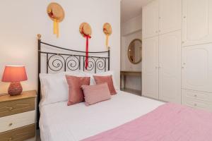 a bedroom with a black and white bed with pink pillows at La Casa Di Nina in Laganas