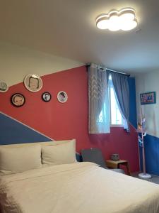 1 dormitorio con cama y pared roja en 埔里潘朵拉 en Puli