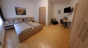 アペートロンにあるWeingut & Gästehaus Markus Tschidaのベッドルーム1室(ベッド1台、デスク、テーブル付)