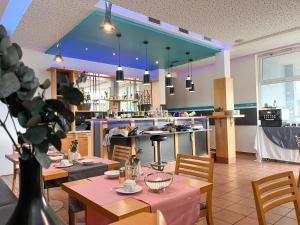 ein Restaurant mit Tischen und Stühlen und eine Küche in der Unterkunft Frühstückspension Ingrid in Neutal