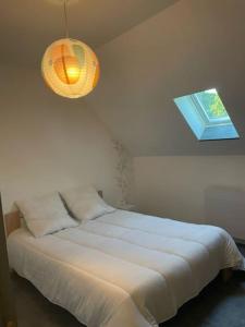 1 dormitorio con cama blanca y ventana en Appartement rénové tout confort, en Mers-les-Bains