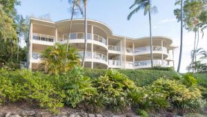 un gran edificio blanco con palmeras delante en Island Point Villa 2 Port Douglas, en Port Douglas