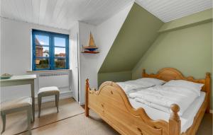 a bedroom with a bed and a desk and a window at Nice Apartment In Allinge With Wifi in Allinge