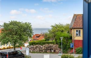 a view of a street with houses and a stone wall at Nice Apartment In Allinge With Wifi in Allinge