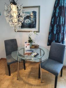 a glass table with two chairs and a plate on it at BnB Haus Weibel in Landquart
