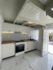 a kitchen with white cabinets and a stove at Villa Pavlina in Karterados