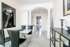 jadalnia z czarnymi krzesłami i białą ścianą w obiekcie SAA- Comfortable Apartment near Puerto Banus w Marbelli