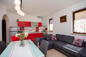 a living room with a couch and a table at Greenhouse family apartments in Rabac