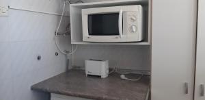 um micro-ondas sentado em cima de uma prateleira com uma televisão em Apartamento Gemelos XII -23 em Benidorm