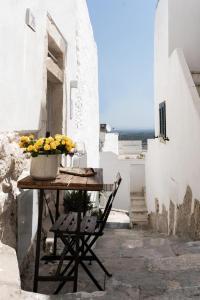a table with a vase of flowers on top of a building at Cà Bella Vista in Ostuni