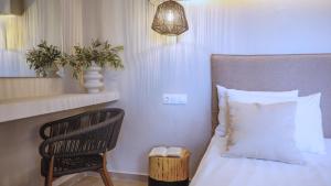 a bedroom with a bed and a chair and a lamp at Fata Morgana Studios & Apartments in Frangokastello