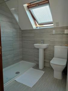 a bathroom with a sink and a toilet and a skylight at Charming Cottage near Cartmel with free Spa access in Holker