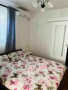 a bedroom with a bed with pink flowers on it at Rooms Verda in Senj