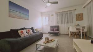 a living room with a couch and a table at STAY Kapparis Symphony in Paralimni
