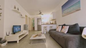 a living room with a couch and a tv at STAY Kapparis Symphony in Paralimni