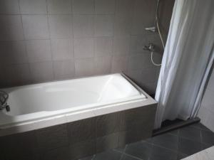 a bath tub in a bathroom with a shower curtain at Panglao Bed and Breakfast Exclusive Villa in Panglao