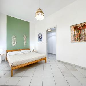 スカウリにあるIl Mare In Giardinoの緑の壁、ベッド付きのベッドルーム1室