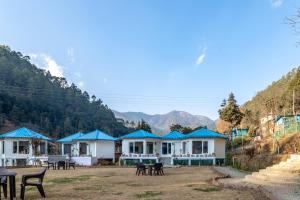 a row of houses with mountains in the background at Blossom Bliss Resort in Bhīm Tāl