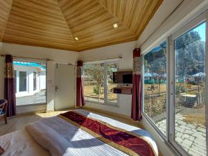 a bedroom with a large window and a bed in it at Blossom Bliss Resort in Bhīm Tāl