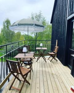 two tables and chairs on a deck with an umbrella at Villa Lyckan in Söråker