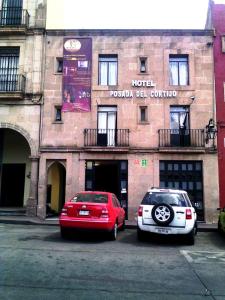 two cars parked in a parking lot in front of a hotel at Hotel Posada del Cortijo in Morelia