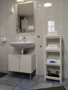een witte badkamer met een wastafel en een spiegel bij MARIJA APARTMAN in Osijek