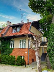 una casa de ladrillo con un árbol delante de ella en Sopot Parkowa, en Sopot