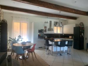 a kitchen with a table and some chairs and a table and a counter at YOGAILO maison de charme in Colombiers