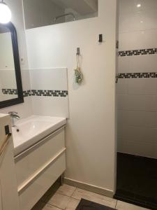 a white bathroom with a sink and a shower at YOGAILO maison de charme in Colombiers