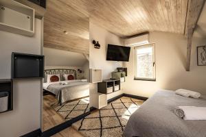 a bedroom with two beds and a flat screen tv at MORE Hotel in Liepāja