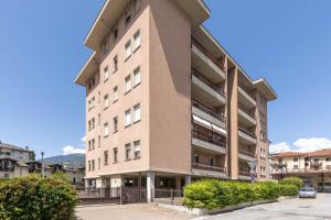 a tall apartment building with a parking lot at Casa vacanze- Debra in Aosta