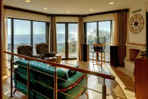 villa a في سكالا ماريون: غرفة معيشة مع أريكة وكراسي ونوافذ