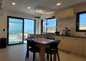 villa a في سكالا ماريون: مطبخ مع طاولة وكراسي مع اطلالة