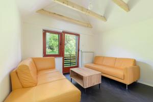 ein Wohnzimmer mit zwei orangenen Sofas und einem Tisch in der Unterkunft Appleby Apartments Kersnik in Bohinj