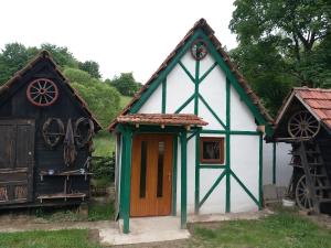 une petite maison blanche et verte avec une roue dans l'établissement Kuća za odmor-Vikendica-, à Visoko