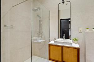 bagno con doccia, lavandino e specchio di Zuid's Charming Gem Apt ad Anversa