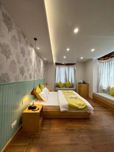 a bedroom with a large bed with yellow pillows at Maple house ladakh in Leh