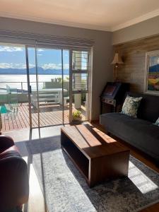 3ColoursBlue Guest House في خليج موسيل: غرفة معيشة مع أريكة وطاولة
