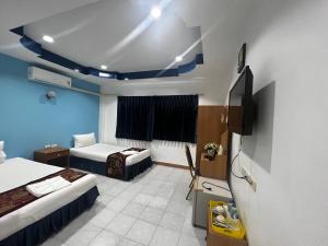 Habitación de hotel con 2 camas y TV en Heaven House en Patong