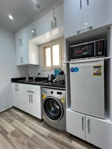 eine Küche mit einer Waschmaschine und einer Mikrowelle in der Unterkunft BS Lodging 15 - Next to Dream Beach in Hurghada