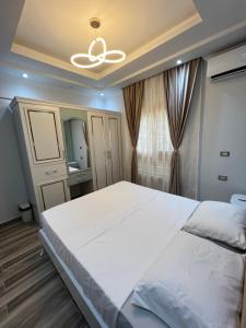 ein Schlafzimmer mit einem großen weißen Bett und einem Spiegel in der Unterkunft BS Lodging 15 - Next to Dream Beach in Hurghada