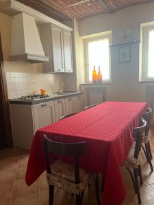 eine Küche mit einem Tisch und einem roten Tischtuch darauf in der Unterkunft Ca' dal Bertu - Cascina in Monferrato in Rosignano Monferrato
